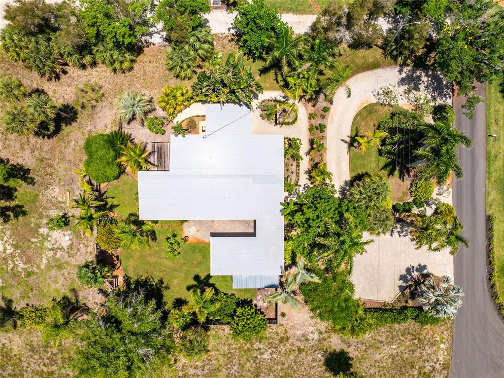An aerial view shows a house with a metal roof surrounded by trees and landscaping — 20 SPANIARDS ROAD, PLACIDA, FL