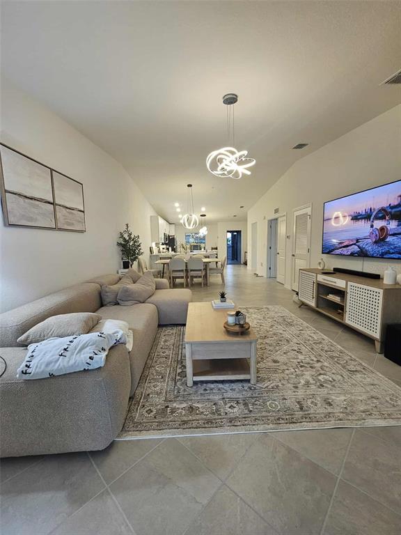 A living room features a beige sectional sofa, a wooden coffee table, and a television — 17470 OPAL SAND DRIVE UNIT 201, VENICE, FL