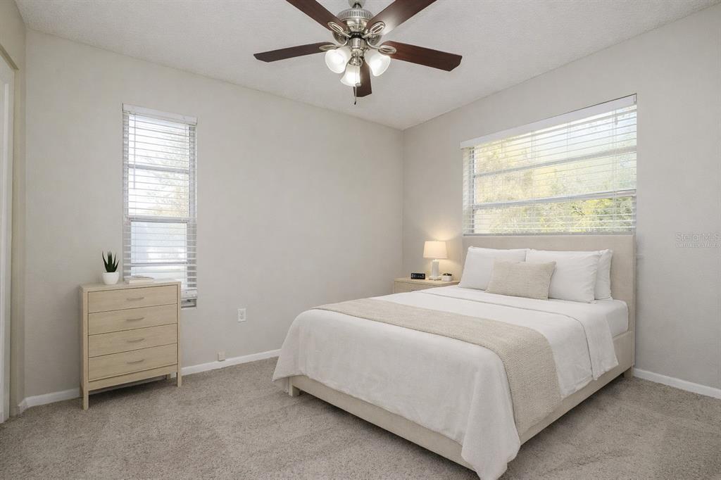A bedroom with a bed, a dresser, a ceiling fan, and windows with blinds — 505 E MORGAN STREET, TARPON SPRINGS, FL