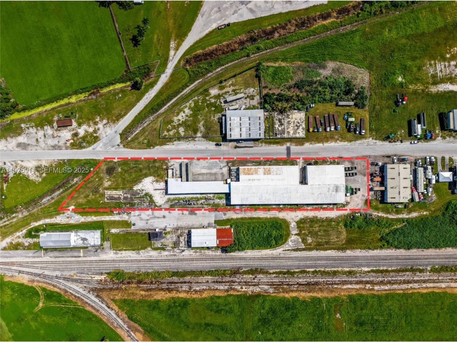 An aerial view shows a rectangular industrial property outlined in red with a large warehouse — 901 NW 9th St, Belle Glade FL 33430, BELLE GLADE, FL