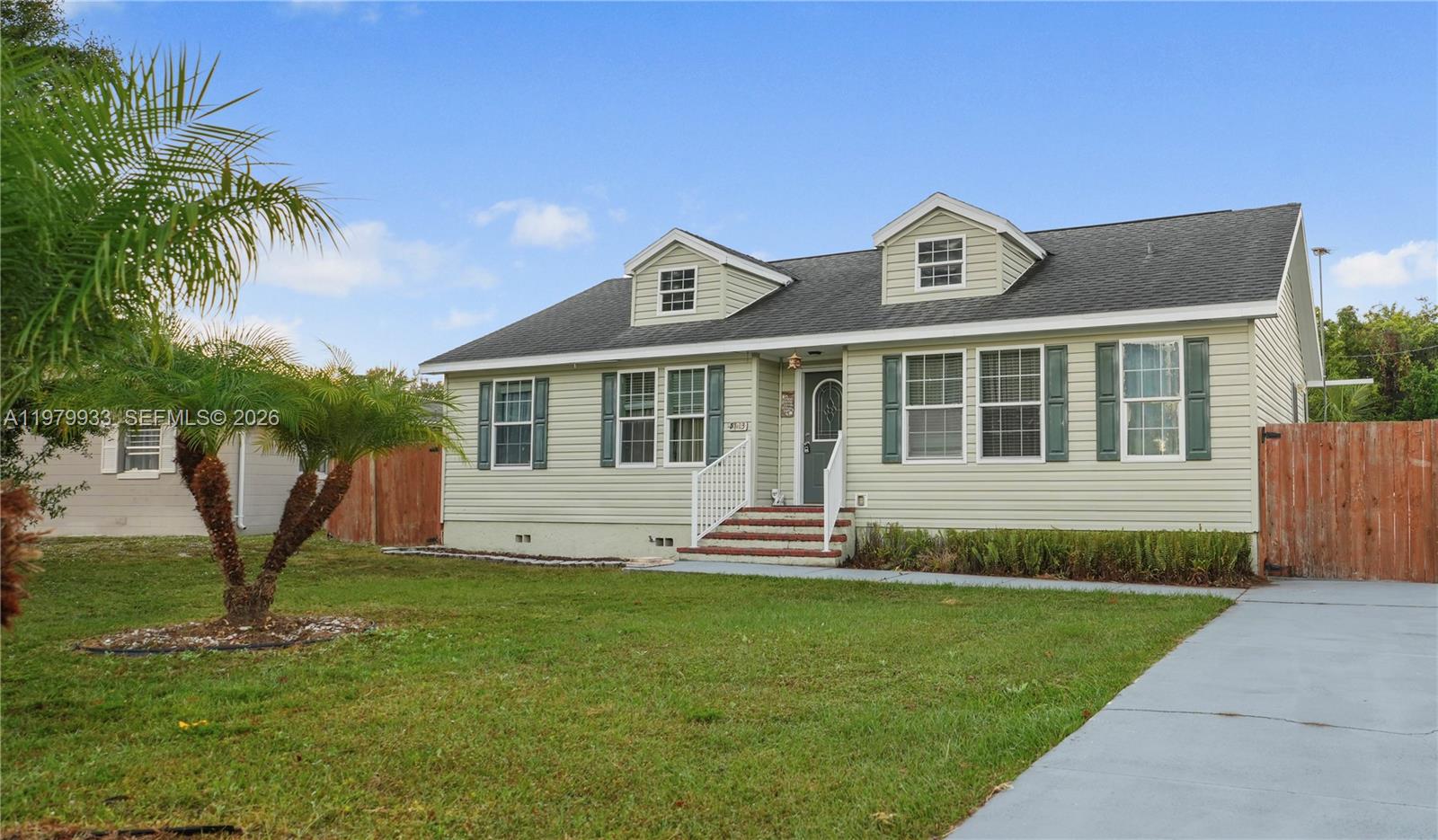 A light green, single-story house with a gabled roof and two dormer windows — 3713 Wild Violet Avenue, Sebring FL 33876, SEBRING, FL