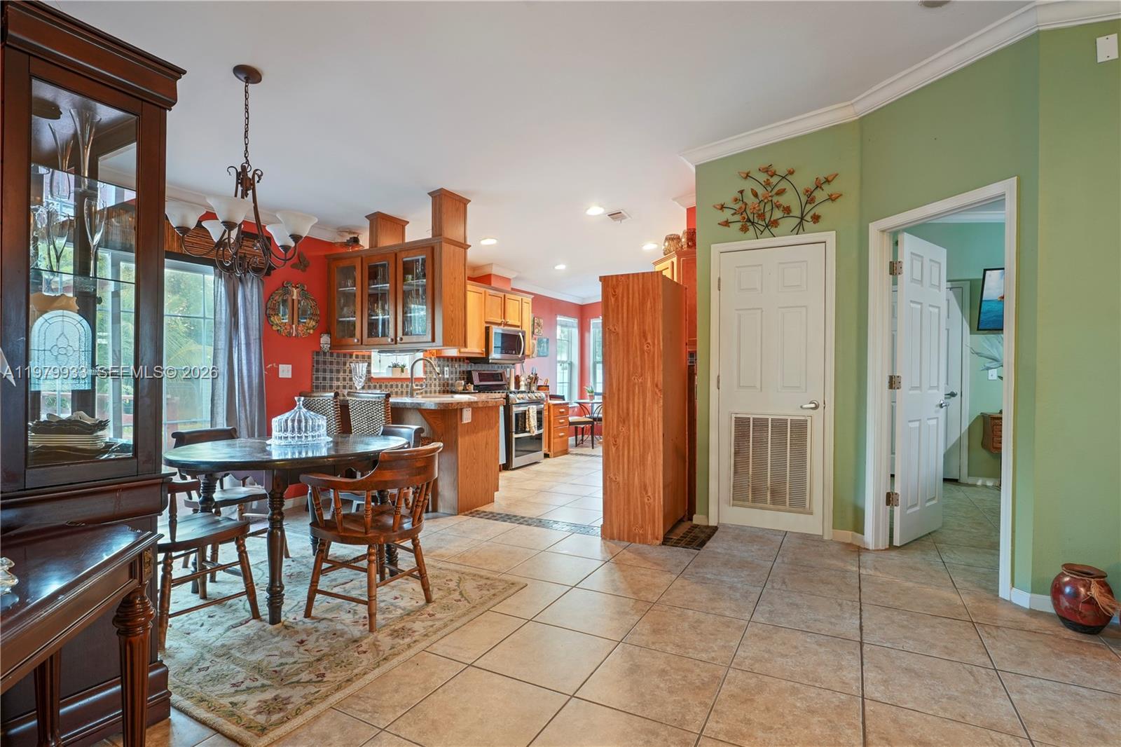 A dining area with a wooden hutch opens into a kitchen with tile flooring — 3713 Wild Violet Avenue, Sebring FL 33876, SEBRING, FL