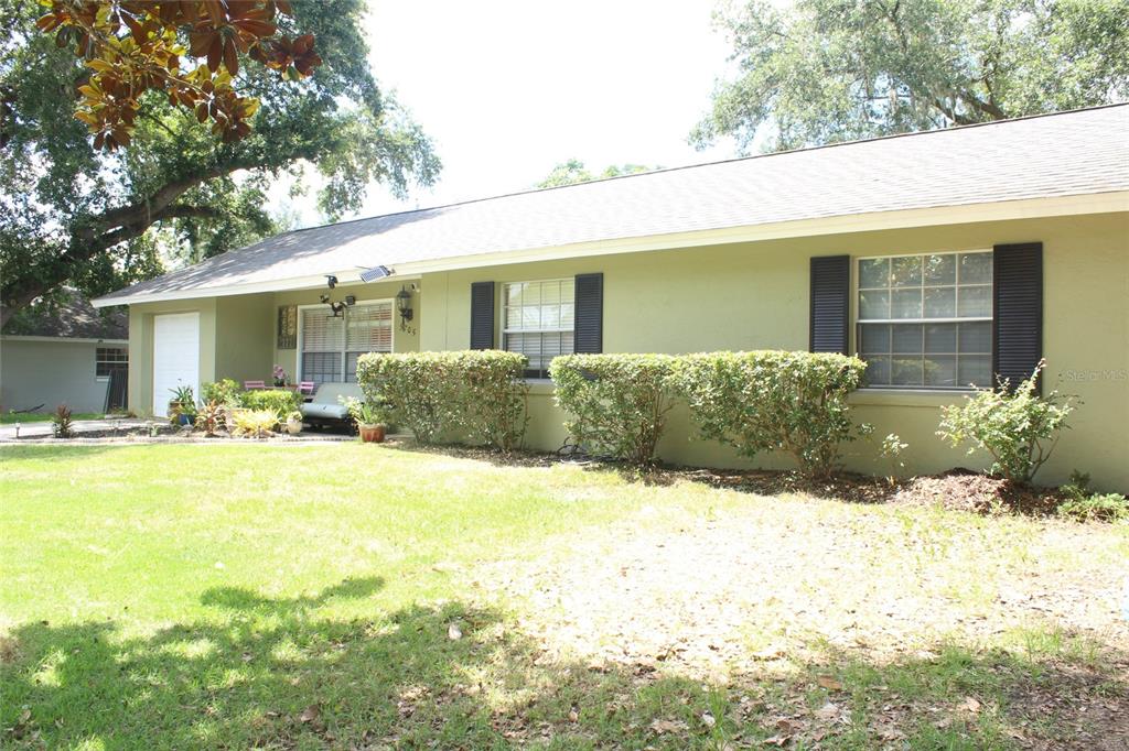 A one-story house with light green siding, black shutters, and a front lawn — 5705 SE 2ND STREET, OCALA, FL