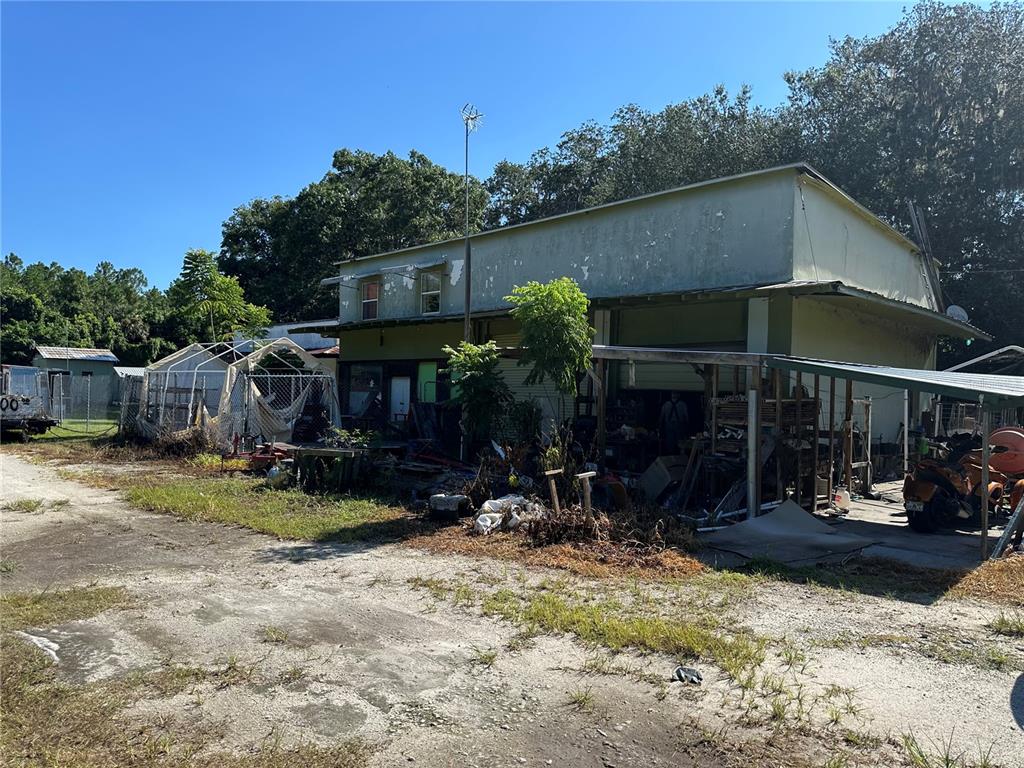 A weathered, light-colored commercial building with a large open bay and an adjacent outdoor shelter — 2660 S US HIGHWAY 17, CRESCENT CITY, FL