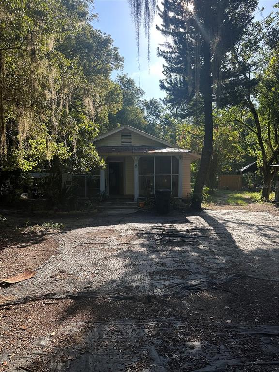 A single-story house with a screened porch sits at the end of a dirt driveway — 2660 S US HIGHWAY 17, CRESCENT CITY, FL