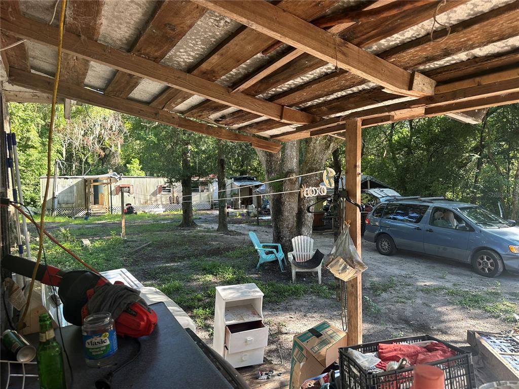 A view from a covered porch looking out toward a yard, trees, and a parked minivan — 2660 S US HIGHWAY 17, CRESCENT CITY, FL
