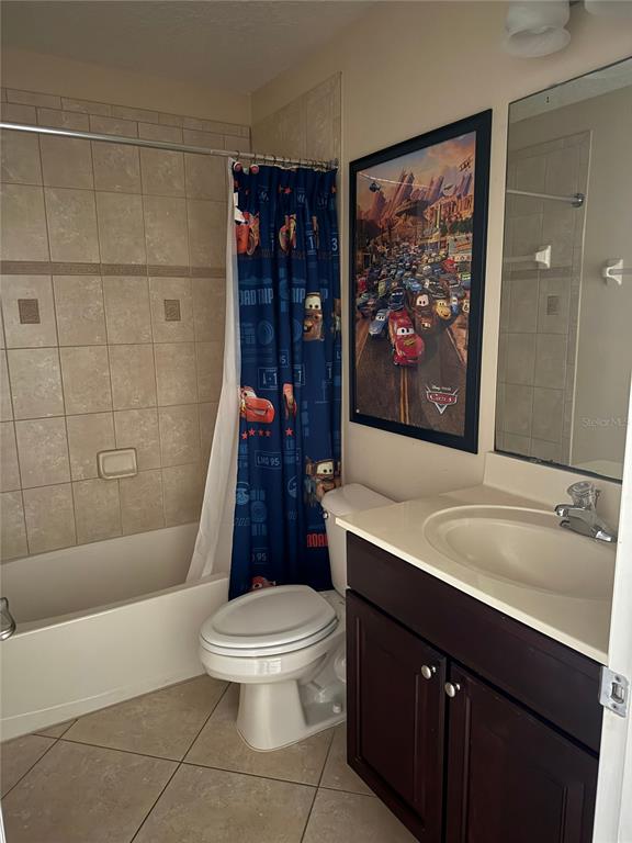 A bathroom features a tiled shower-tub combo, a toilet, and a dark wood vanity — 860 ASSEMBLY COURT, REUNION, FL