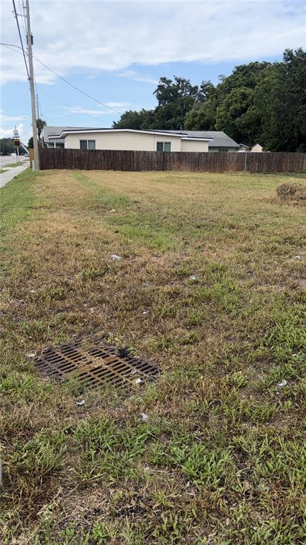 A vacant, grassy lot with a storm drain grate and a wooden fence in back — 4341 LENOX BOULEVARD, ORLANDO, FL