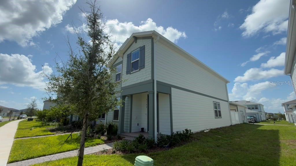 A two-story house with light-colored siding, a covered front porch, and a grassy yard — 4568 ORCHARD VIEW ALLEY, CLERMONT, FL