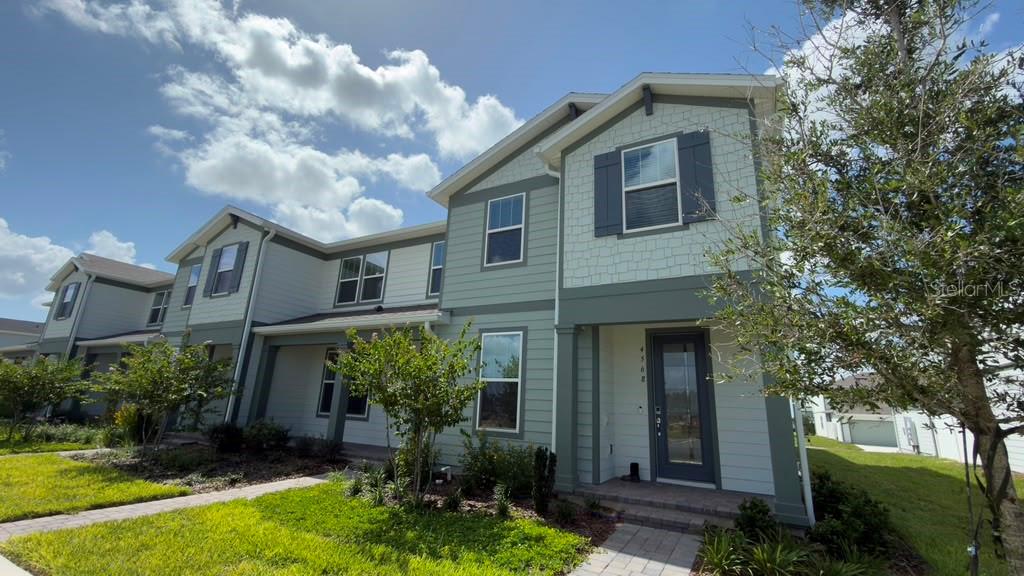 A two-story house with light green siding, dark shutters, and a front entryway — 4568 ORCHARD VIEW ALLEY, CLERMONT, FL