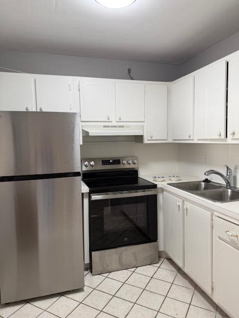 A kitchen features a stainless steel refrigerator, a stove, white cabinets, and a wicker drawer unit — 3320 Lake Osborne Drive # 107, FL 33461, FL