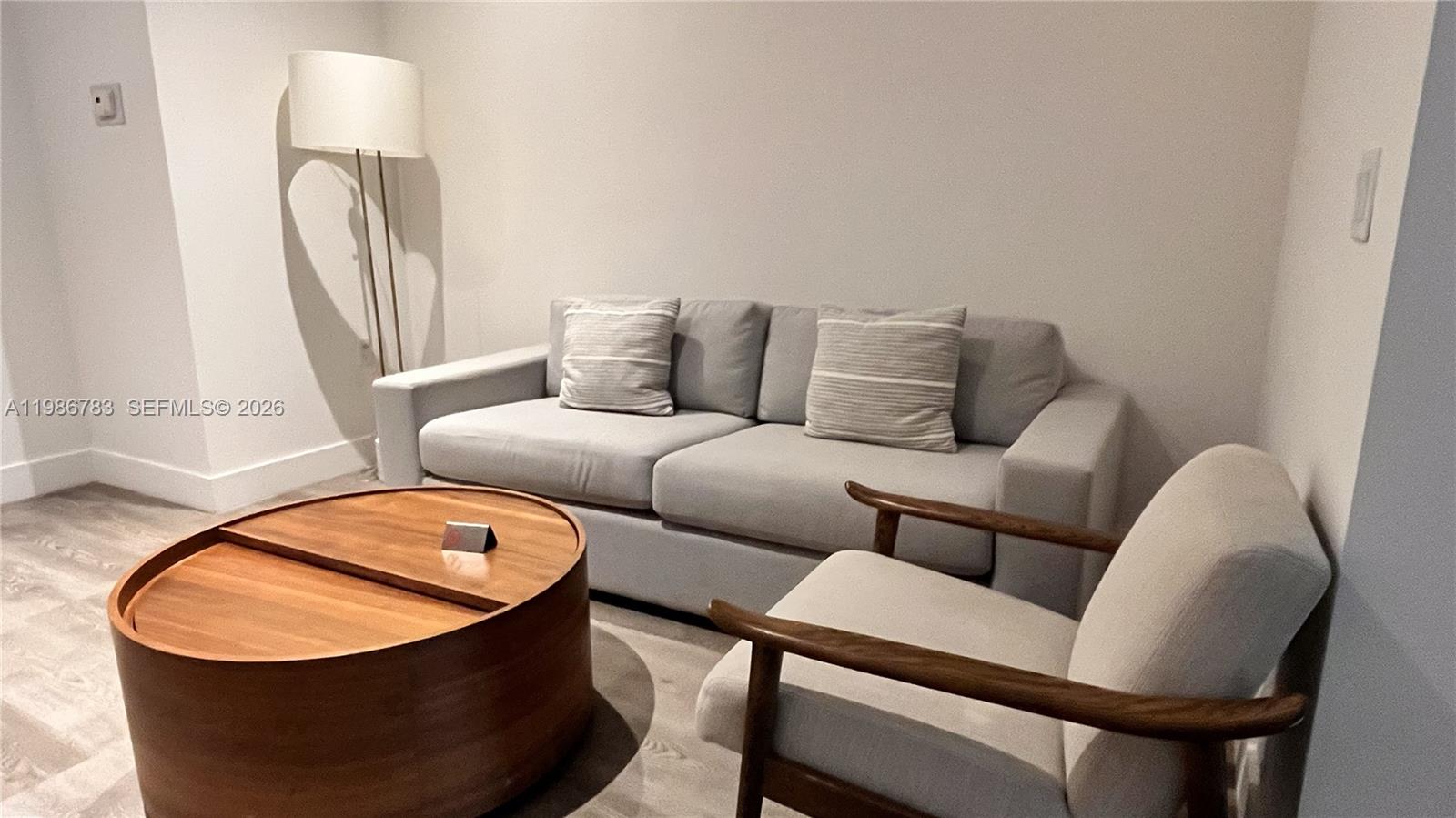 A living room features a gray sofa, a wooden coffee table, and an armchair — 229 SW 9th St # 307, Miami FL 33130, MIAMI, FL