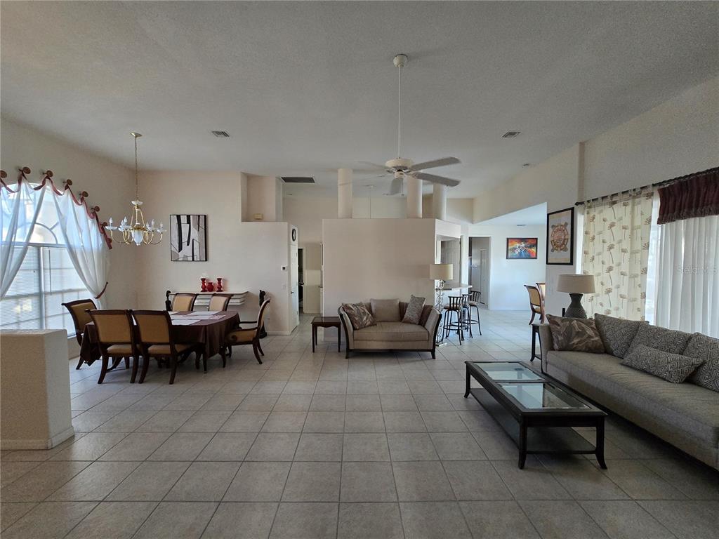 A spacious open-concept living and dining area features tile flooring and high ceilings — 23404 PEACHLAND BOULEVARD, PORT CHARLOTTE, FL