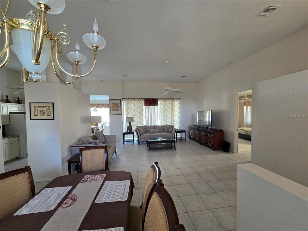 A dining area in the foreground opens into a living room with tile flooring — 23404 PEACHLAND BOULEVARD, PORT CHARLOTTE, FL