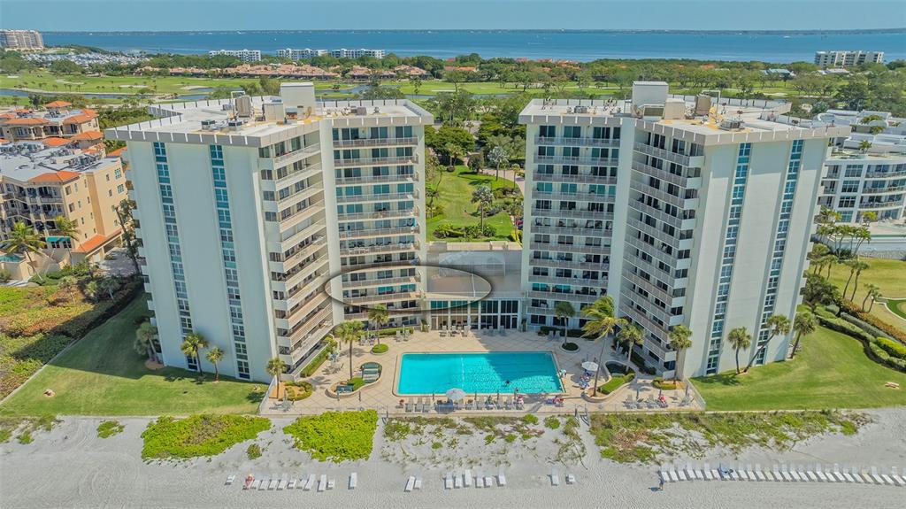 An aerial view of a beachfront condominium complex with a swimming pool and landscaped grounds — 2301 GULF OF MEXICO DRIVE UNIT 33N, LONGBOAT KEY, FL