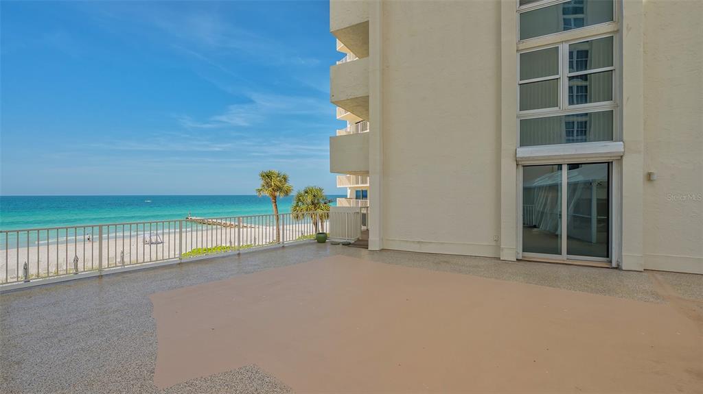 A large, beige-floored balcony overlooks a sandy beach and the ocean — 2301 GULF OF MEXICO DRIVE UNIT 33N, LONGBOAT KEY, FL