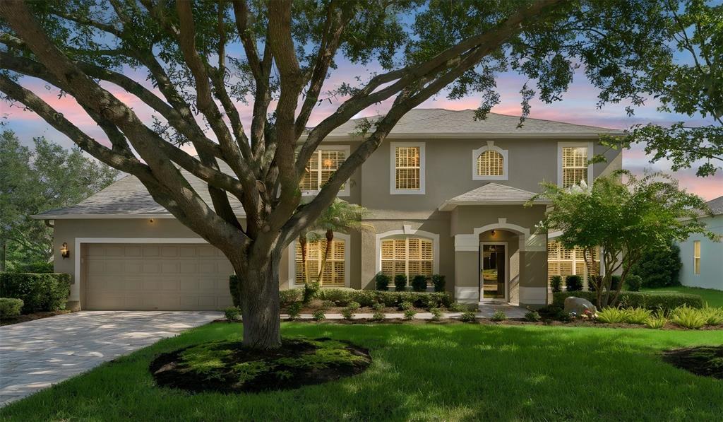 A two-story suburban house with a large tree in the front yard and a garage — 626 ENGLISH LAKE DRIVE, WINTER GARDEN, FL