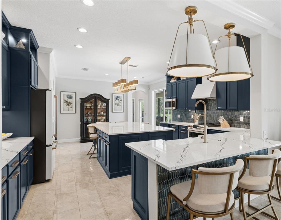 A kitchen with navy blue cabinets, white marble countertops, and a large central island — 626 ENGLISH LAKE DRIVE, WINTER GARDEN, FL