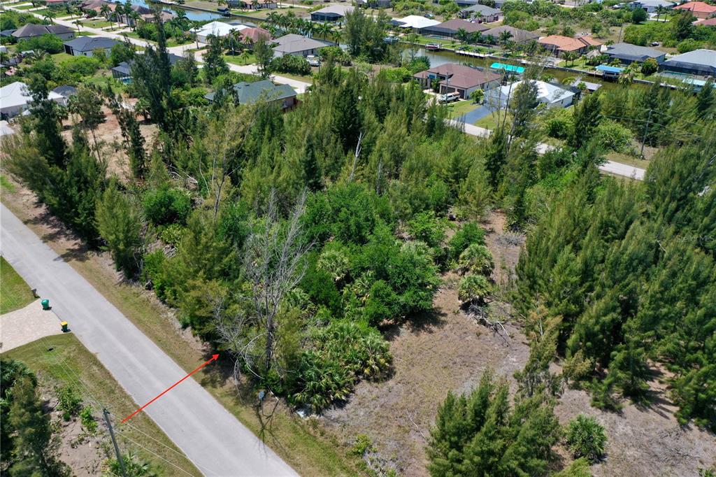 An aerial view shows a vacant, tree-covered residential lot next to a paved road — 8409 ANTWERP CIRCLE, PORT CHARLOTTE, FL