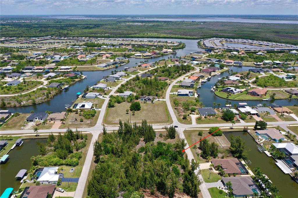 An aerial view of a vacant residential lot surrounded by houses and canal waterways — 8409 ANTWERP CIRCLE, PORT CHARLOTTE, FL