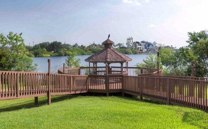 A wooden gazebo sits on a deck overlooking a lake with a water park nearby — 6165 CARRIER DRIVE UNIT 3311, ORLANDO, FL