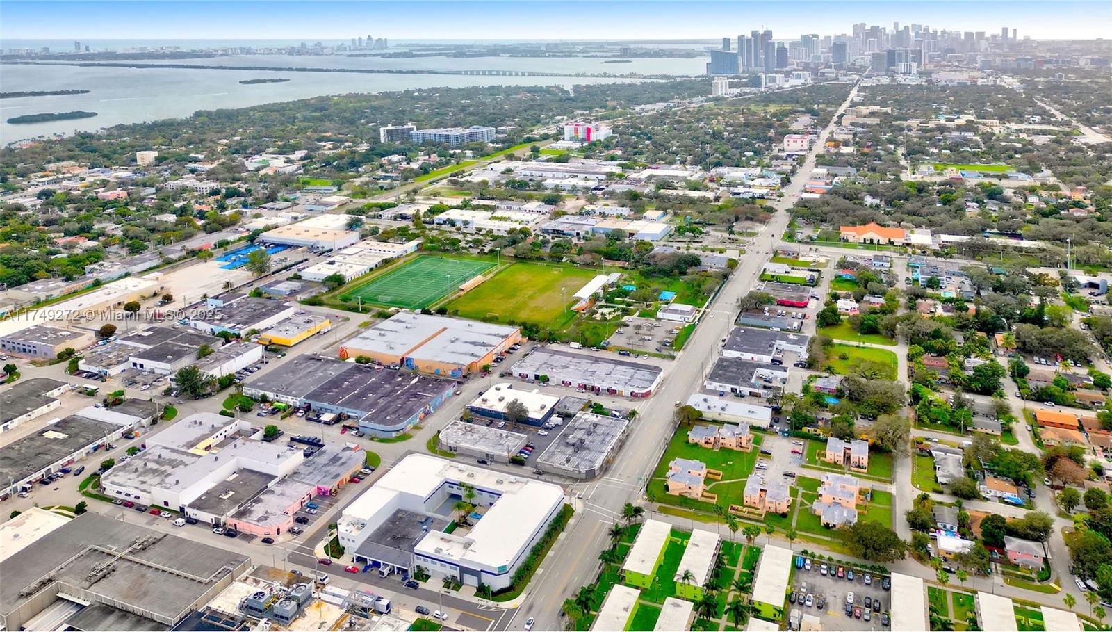 An aerial view shows a neighborhood with industrial buildings, a sports field, and residential complexes — 235 NE 67th St # 3, Miami FL 33138, MIAMI, FL