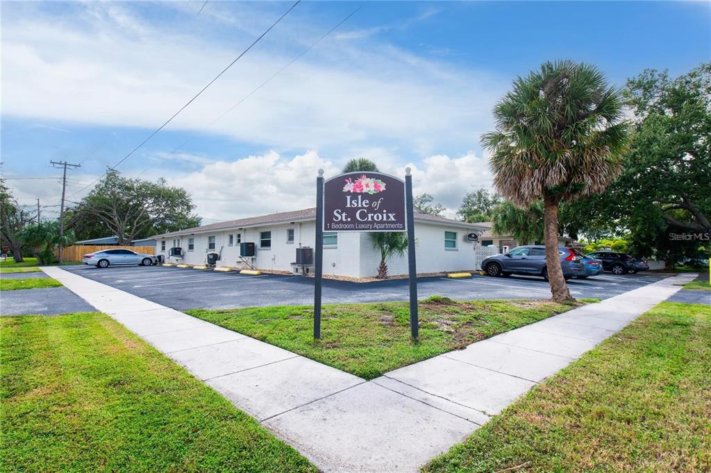 A single-story apartment building with a parking lot and a sign in the foreground — 500 75TH AVENUE N, ST PETERSBURG, FL
