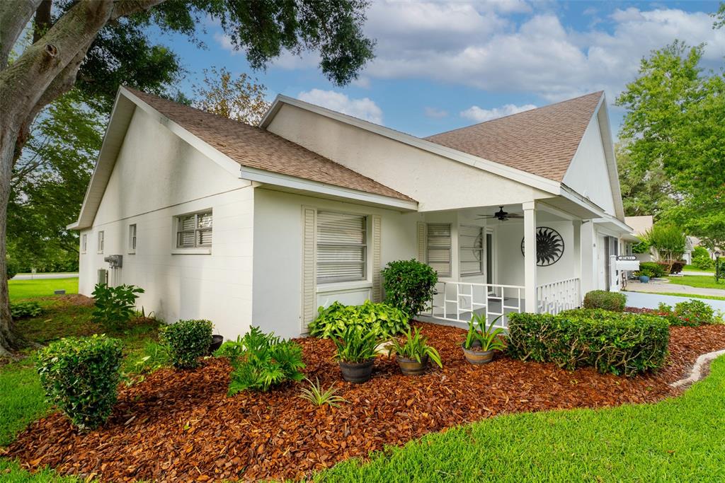A white house with a brown shingled roof and a covered front porch with landscaping — 8743 SW 90TH LANE UNIT A, OCALA, FL