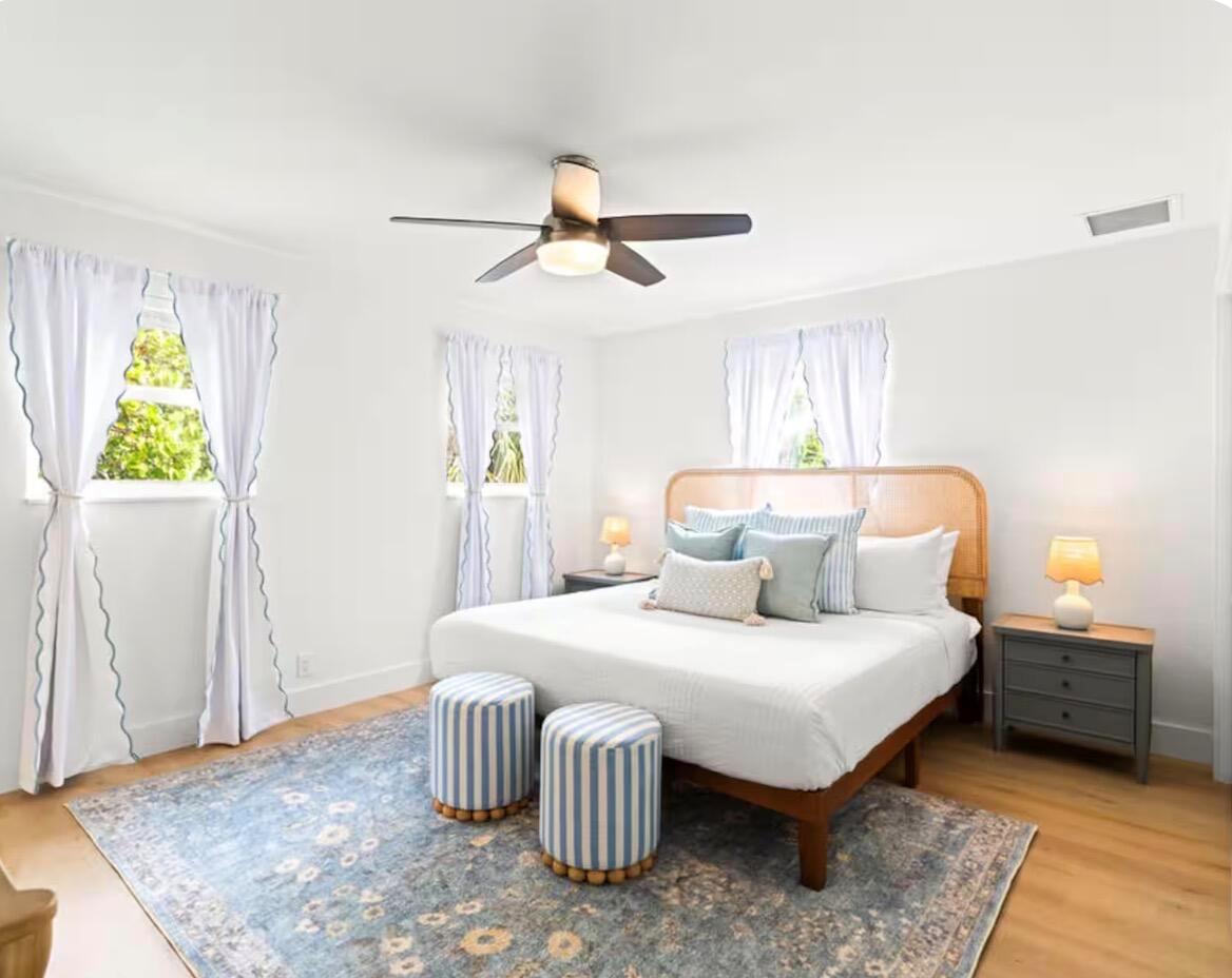 A kitchen features white cabinets, stainless steel appliances, gray subway tile backsplash, and wood flooring — 1216 Surf Road, Singer Island FL 33404, SINGER ISLAND, FL