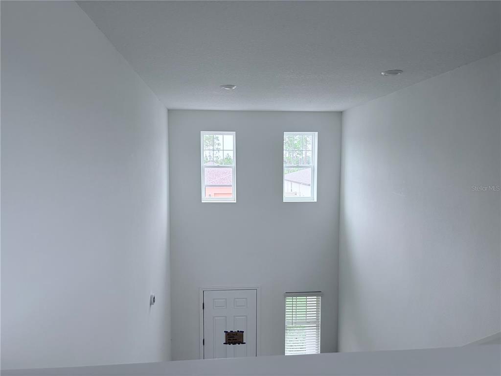 A high-ceilinged entryway features white walls, two upper windows, and a lower door — 3213 VICEROY COURT, POINCIANA, FL