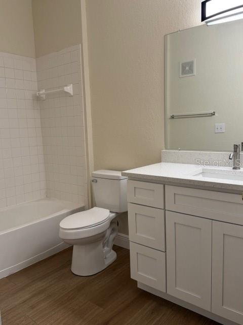 A bathroom with a white vanity, toilet, and a shower-tub combination with white tile walls — 3707 CONROY ROAD UNIT 1712, ORLANDO, FL
