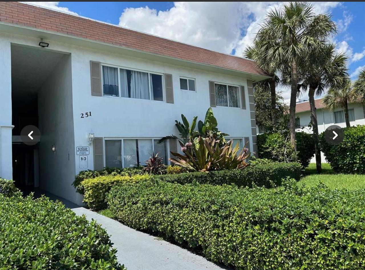 A two-story white apartment building features a brown roof, palm trees, and manicured hedges — 151 SE 6th Avenue # 12, Pompano Beach FL 33060, POMPANO BEACH, FL