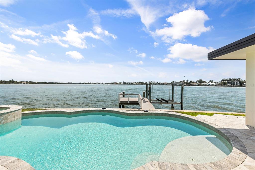 A swimming pool overlooks a private dock on a large body of water — 4598 CLEARWATER HARBOR DRIVE S, LARGO, FL