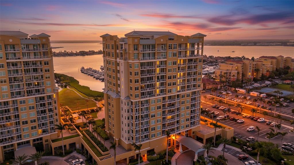 An aerial view of two high-rise residential buildings near a marina at sunset — 130 RIVIERA DUNES WAY UNIT PH202, PALMETTO, FL