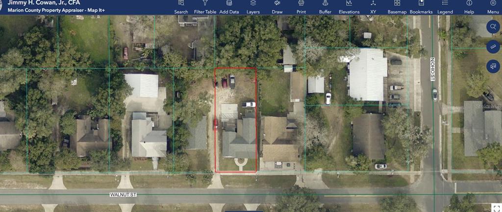 A white, single-story house with a front porch and a salon sign on the exterior — 20707 WALNUT STREET, DUNNELLON, FL