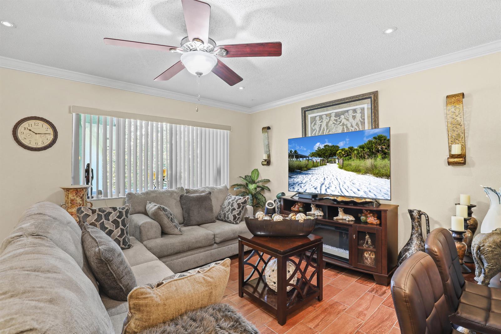 A living room features a grey sectional sofa, a ceiling fan, and a television console — 3100 Springdale Boulevard # 308, Palm Springs FL 33461, PALM SPRINGS, FL