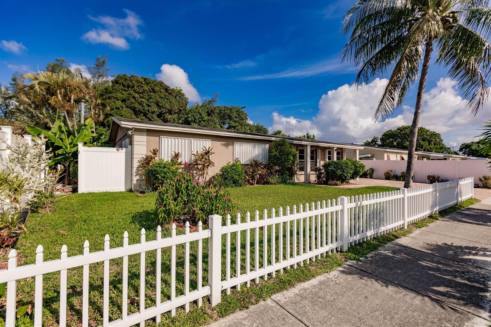 A single-story house with a white picket fence, a palm tree, and a green lawn — 4241 NE 1st Terrace, Pompano Beach FL 33064, POMPANO BEACH, FL