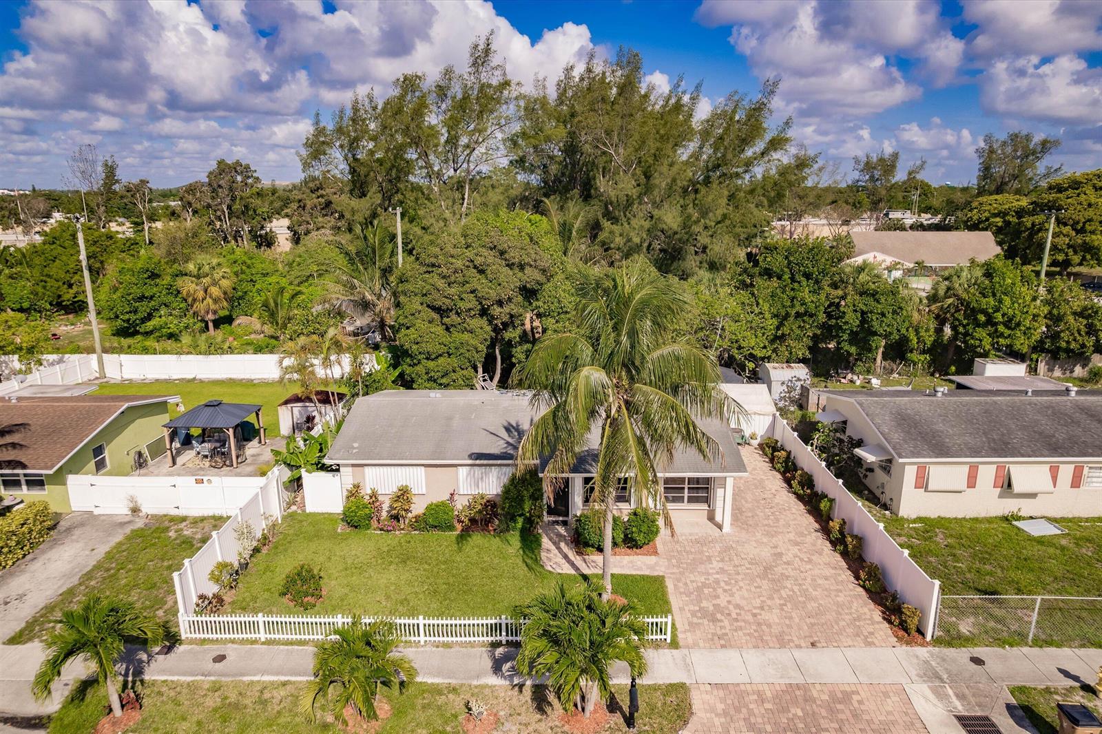 An aerial view shows a single-story house with a paved driveway and a front lawn — 4241 NE 1st Terrace, Pompano Beach FL 33064, POMPANO BEACH, FL