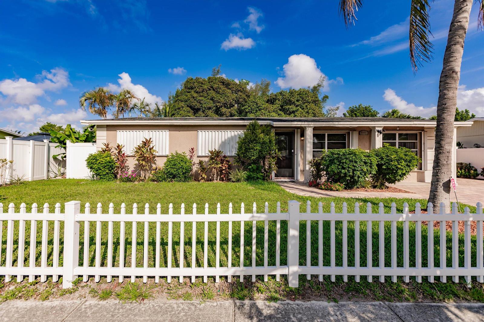A single-story house with a white picket fence, a lawn, and a palm tree — 4241 NE 1st Terrace, Pompano Beach FL 33064, POMPANO BEACH, FL