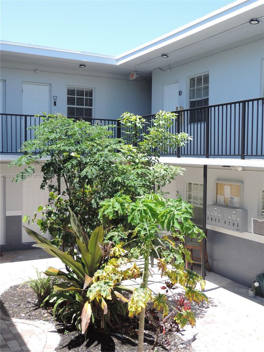 A courtyard with a central garden bed surrounded by two-story apartment building walkways — 3615 Thomas Ave # 11, Miami FL 33133, MIAMI, FL