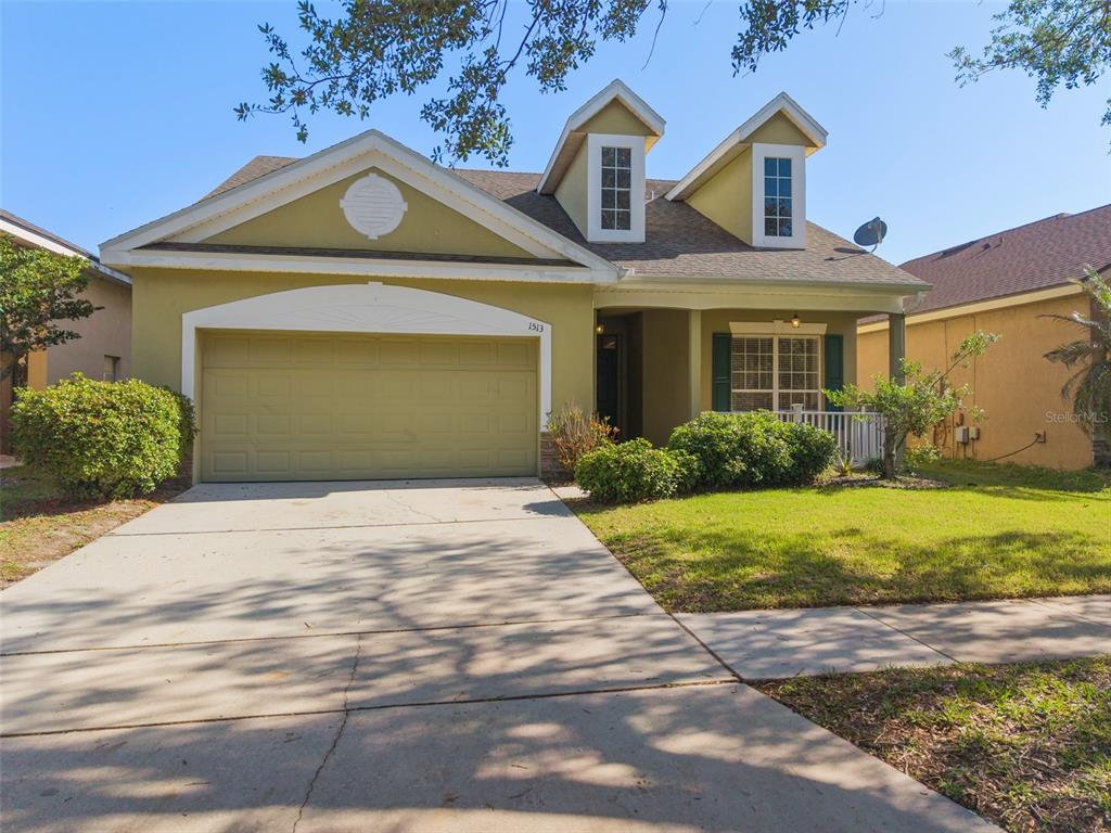 A two-story house with a green exterior, a two-car garage, and two dormer windows — 1513 HARRIER DRIVE, ORLANDO, FL