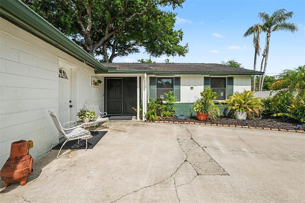 A single-story house with a white exterior, dark shutters, and a concrete driveway — 8115 N OLA AVENUE, TAMPA, FL