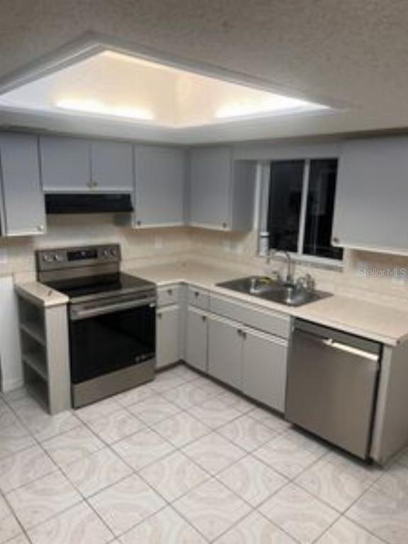 A kitchen features light gray cabinets, stainless steel appliances, tile flooring, and a recessed ceiling light — 17624 SE 108TH TERRACE, SUMMERFIELD, FL