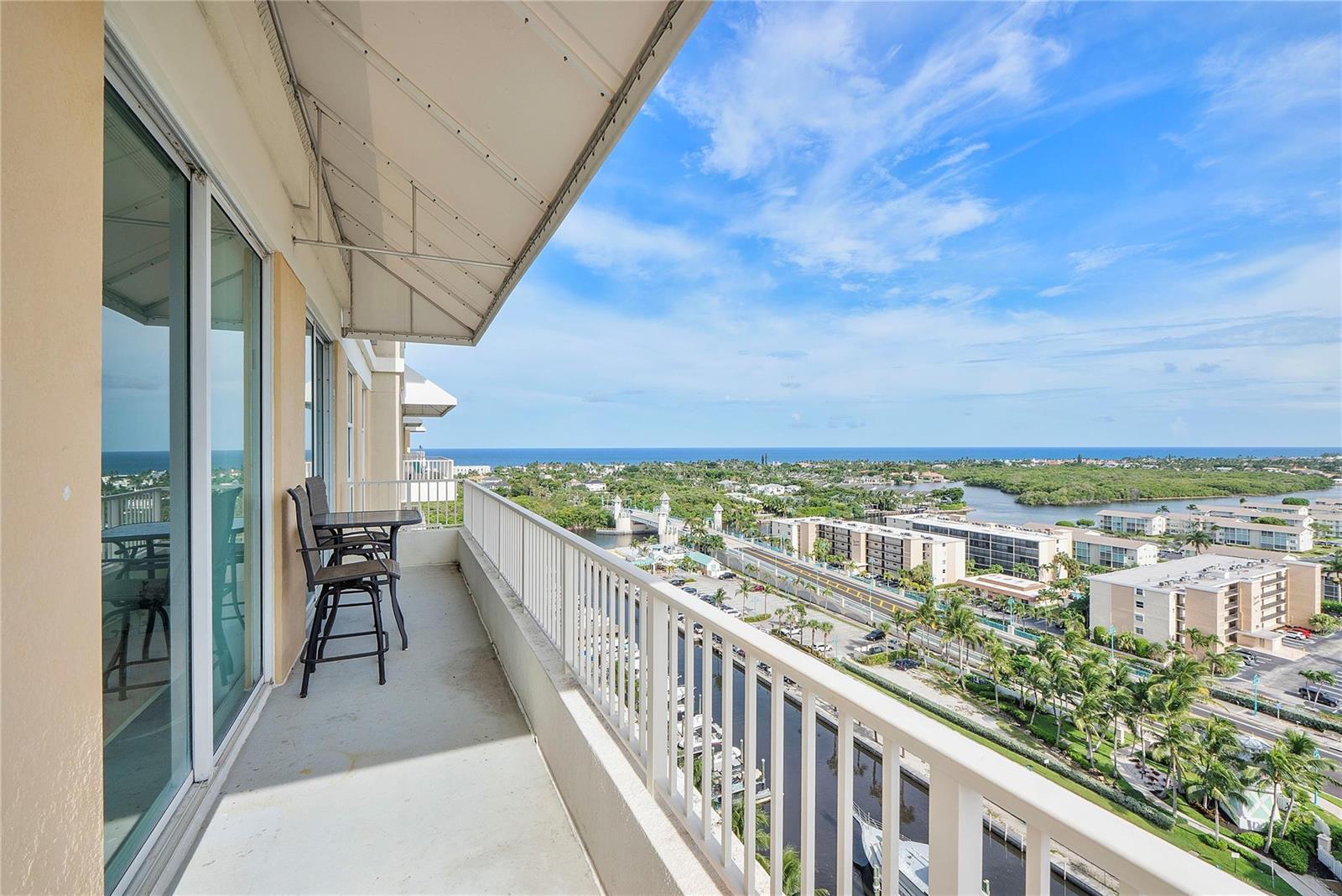 A high-rise balcony with a small table and chairs overlooks a coastal waterway and bridge — 625 Casa Loma Boulevard # 1608, Boynton Beach FL 33435, BOYNTON BEACH, FL
