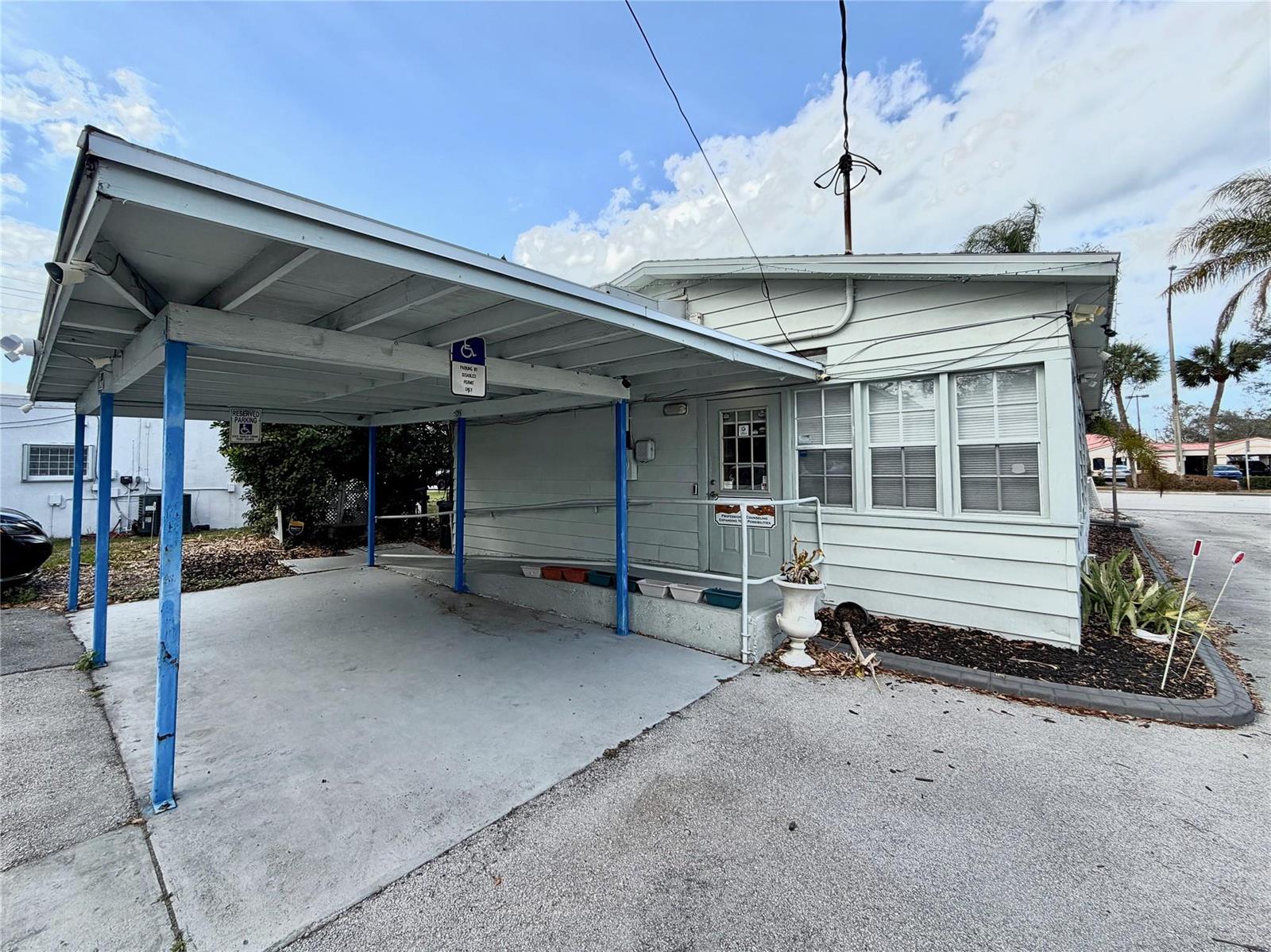 A light-colored building exterior features a covered carport and a wheelchair-accessible ramp — 1925 20th Street, Vero Beach FL 32960, VERO BEACH, FL