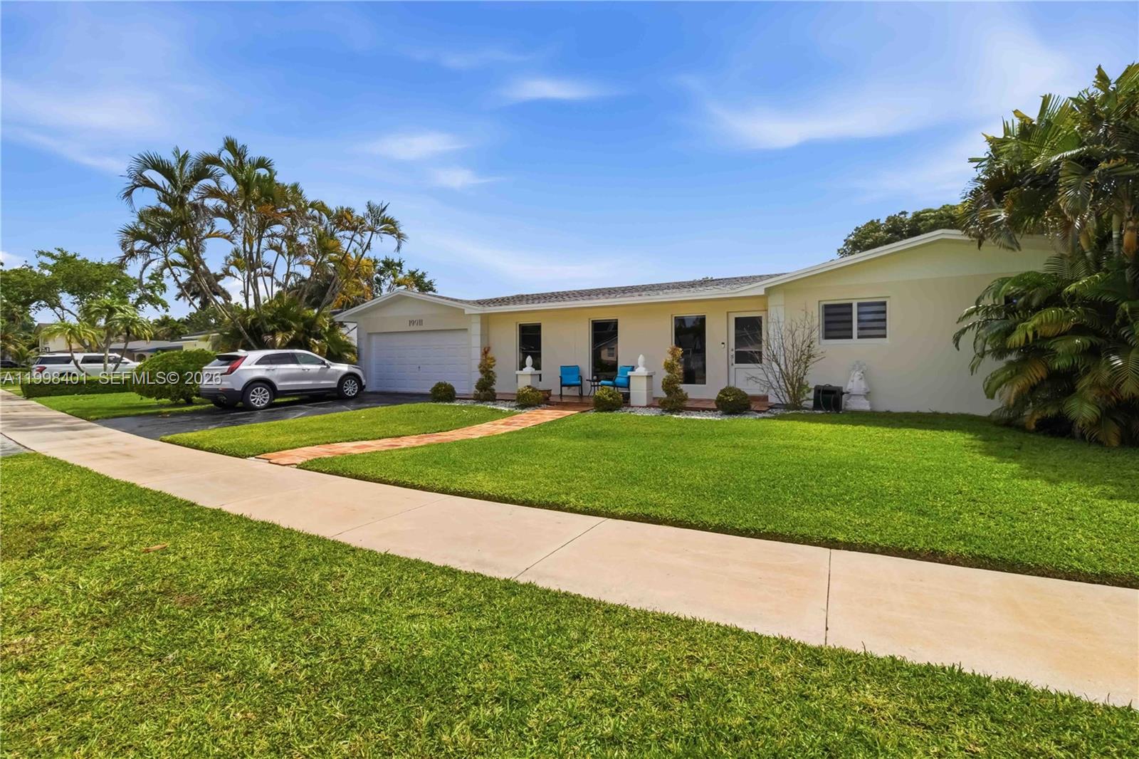 A single-story house with a garage, tiled walkway, and palm trees at sunset — 19911 SW 84th Ave, Cutler Bay FL 33189, CUTLER BAY, FL