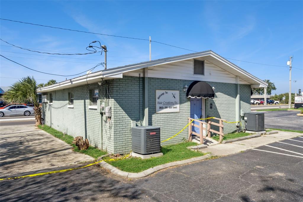 A light green brick commercial building with a blue door and a black awning — 1610 1ST STREET S, WINTER HAVEN, FL