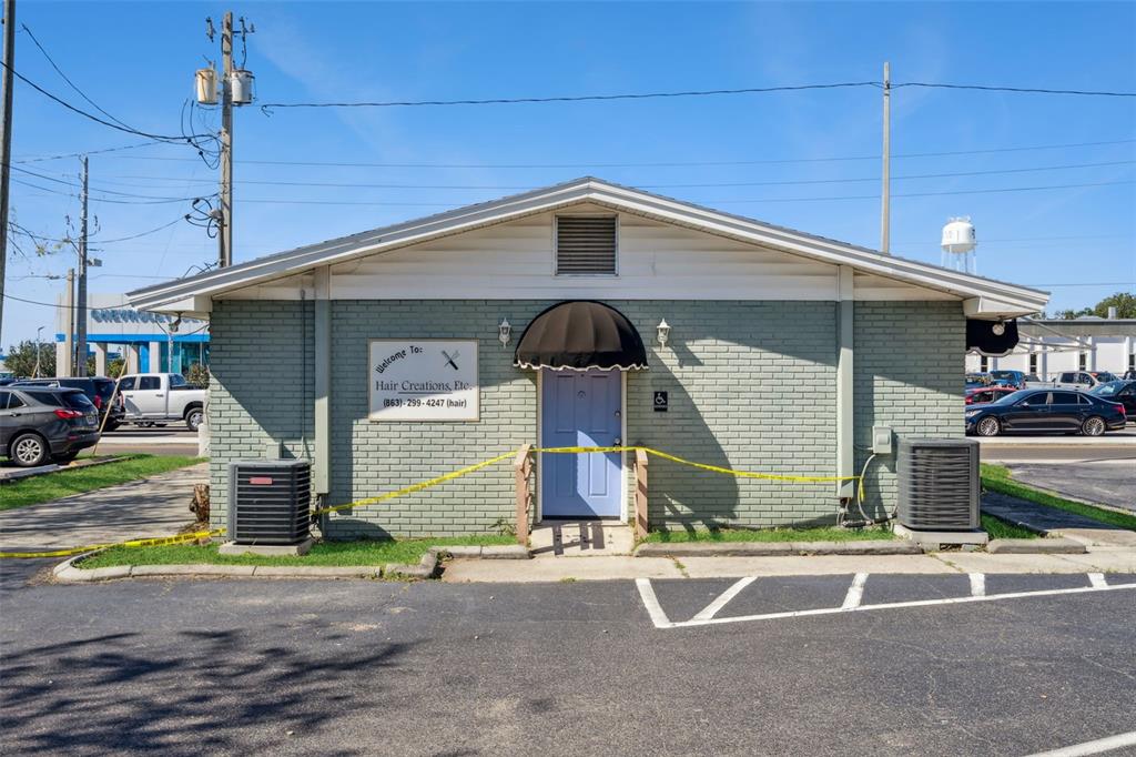 A light green brick building with a blue door and yellow caution tape across it — 1610 1ST STREET S, WINTER HAVEN, FL