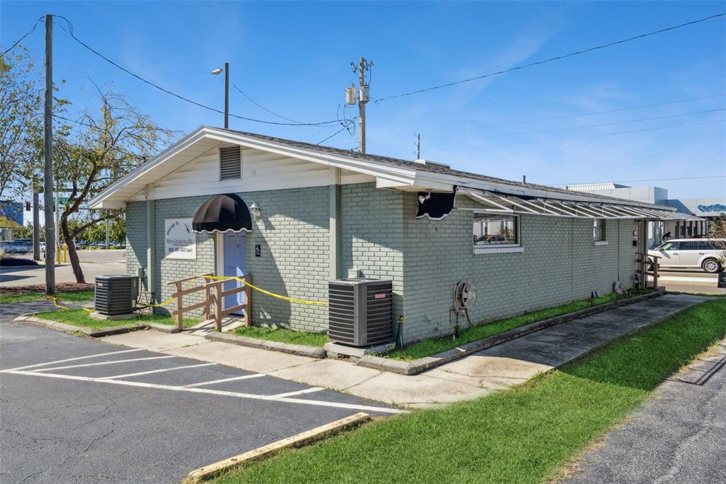 A single-story, light green brick commercial building with a black awning and two AC units — 1610 1ST STREET S, WINTER HAVEN, FL