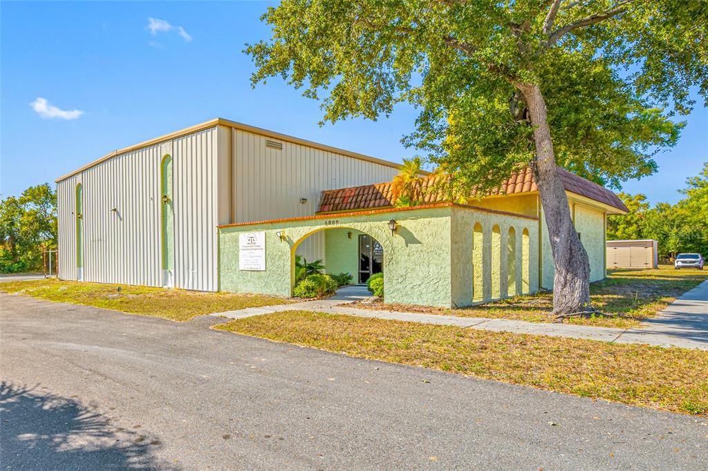 A light green building with a metal warehouse section and a tiled roof entrance — 5802 N OCCIDENT STREET, TAMPA, FL